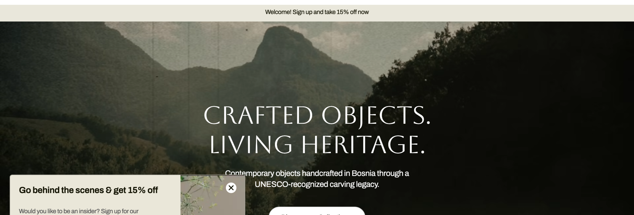 WAGAhomepagehero, whiteserifheadline'CraftedObjects.LivingHeritage.'overamistyBosnianmountainlandscape,witha'DiscoverourCollections'buttonandcategorypillsforFurniture,HomeDecor,ServingTraysandCuttingBoards